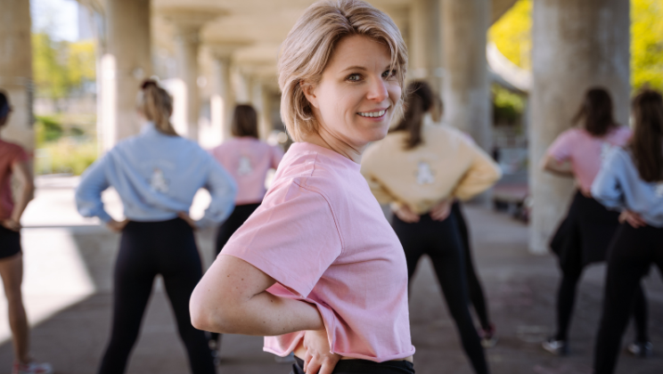 Bild på Flow and glow grundaren Marica som ler mot kameran iklädd rosa tröja